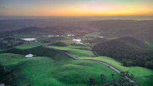 Sunset aerial view of Mount Alma Road winding through green hills and valleys near Adelaide, South Australia
