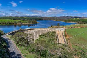 Myponga Reservoir surrounded by rolling hills and calm reflections in South Australia – landscape photography by Junrui Ye