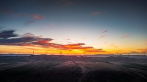 Drone aerial view of wind turbines along Worlds End Highway at sunset, glowing in warm golden light across the South Australian outback – landscape photography by Junrui Ye