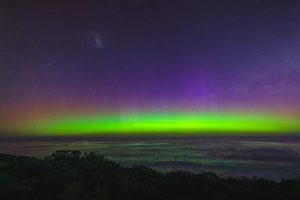 Aurora Bands Over the Sea – Muhan Viewpoint Southern Lights with green and purple aurora bands above the ocean at Muhan Viewpoint, with the Large Magellanic Cloud visible.