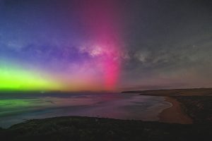 Milky Way and Aurora Above Parsons Beach Milky Way arch above Parsons Beach with a bright pink aurora beam and green aurora glow rising from the southern horizon.