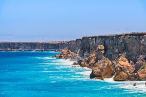 Endless limestone cliffs stretching into the distance at Head of Bight, where turquoise coastal waters and white surf meet the vast Southern Ocean.