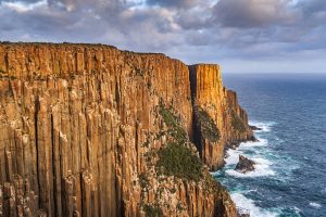 Vertical dolerite cliffs at The Gap along the Cape Raoul Track, with waves crashing below on the Tasman Peninsula coastline.