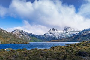 Snow-capped Cradle Mountain rising above the blue waters of Dove Lake under a clear sky in Tasmania