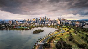 Melbourne City Skyline from Albert Park at Sunset – Aerial View Victoria Australia Melbourne city skyline from Albert Park at sunset with lake and clouds seen from aerial drone view in Victoria Australia