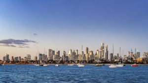 Melbourne City Skyline from St Kilda Pier at Sunset – Victoria Australia Melbourne city skyline at sunset from St Kilda Pier with boats on the water and golden light reflecting on buildings in Victoria Australia