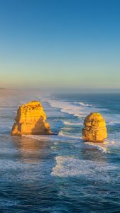 Golden Light at the Twelve Apostles – Great Ocean Road Sunset Landscape Australia Golden sunlight on the Twelve Apostles in Victoria Australia with waves hitting limestone sea stacks along the Great Ocean Road