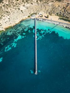 Top-down aerial view of Point Sinclair Jetty extending over clear turquoise water on the Eyre Peninsula, South Australia